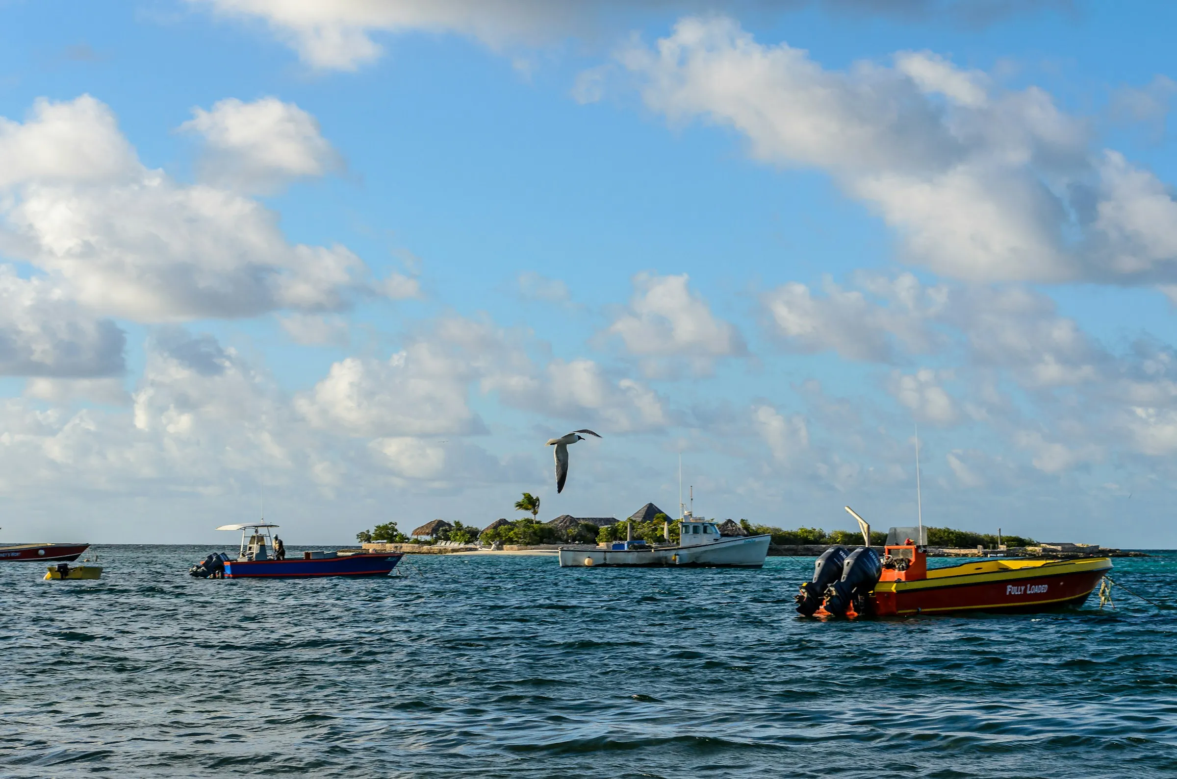 Aerial view of small boats on turquoise water near an Anguilla shoreline.