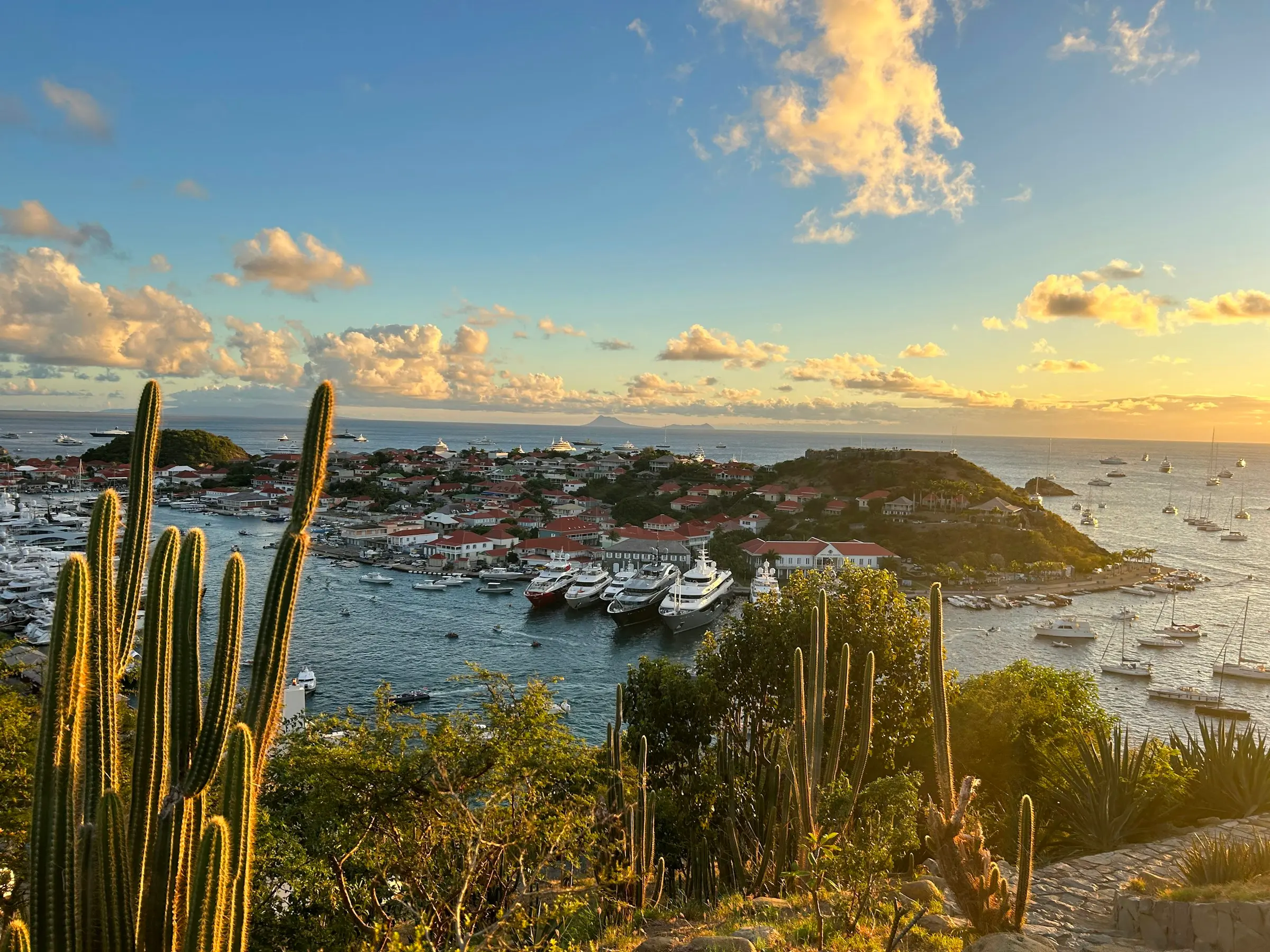 Gustavia harbor at golden hour with yachts.
